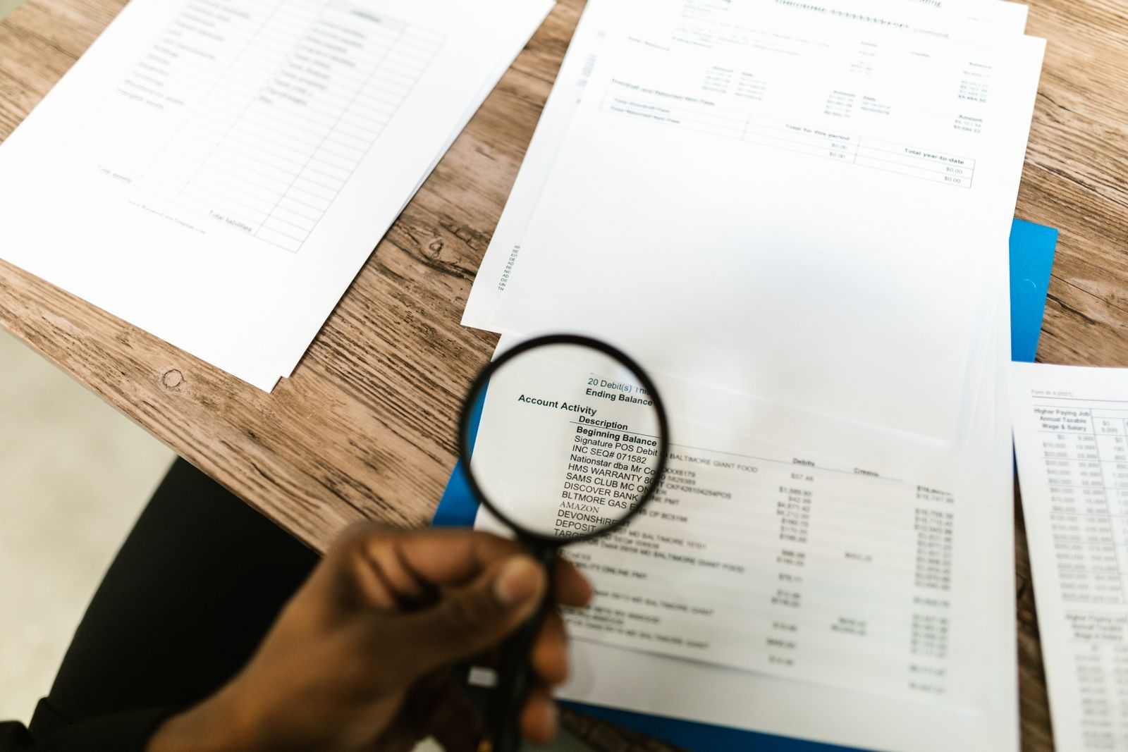 A reviewer checking a document line by line with a magnifying glass