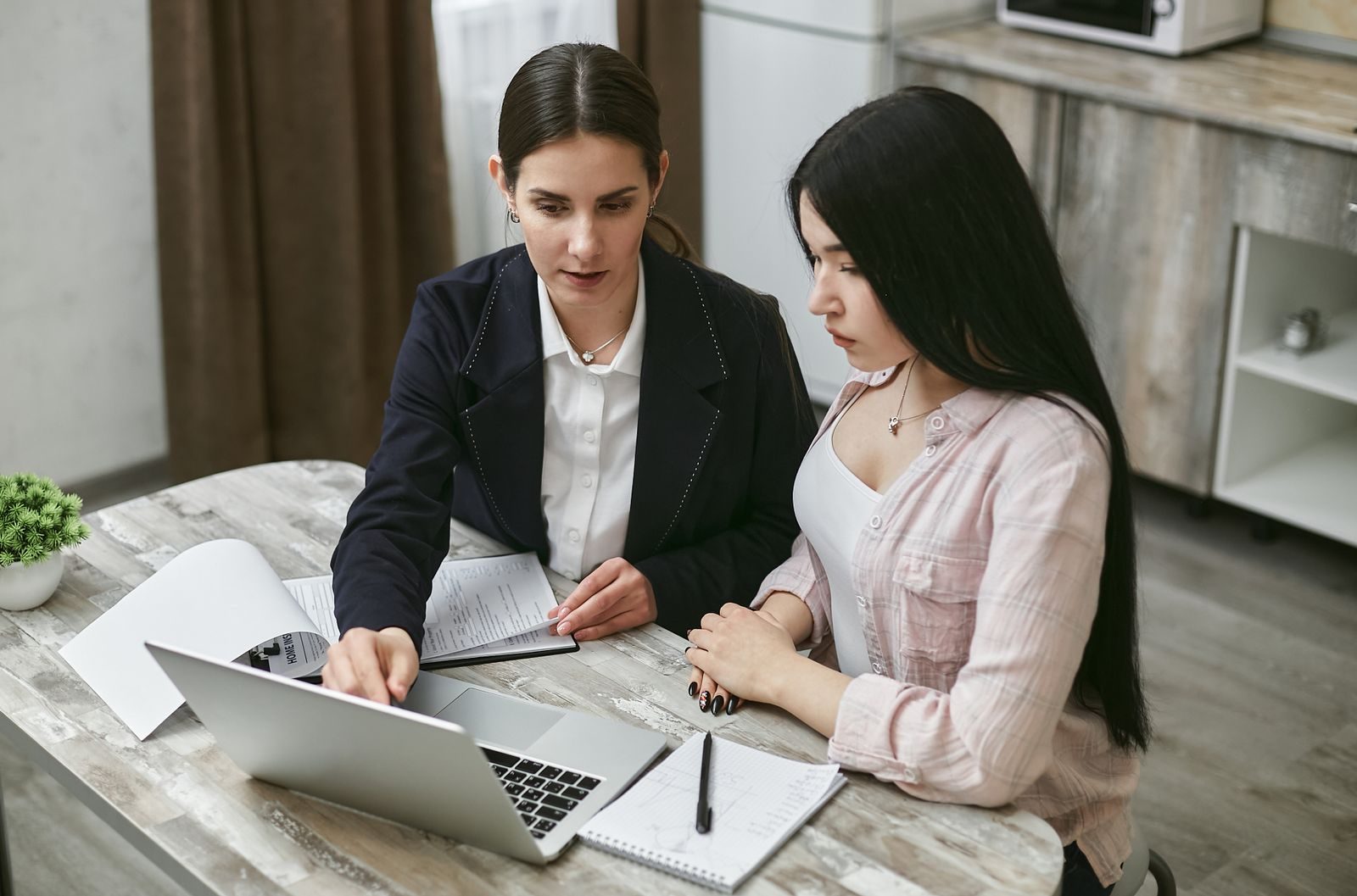 Two consultants reviewing work together on a laptop