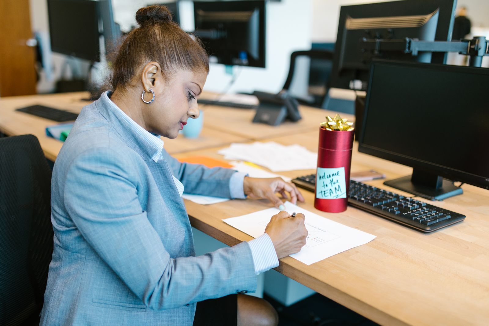 A new starter at her desk on day one, with a welcome note beside her